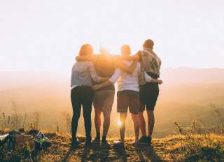 Group-friends-hugging-after-hiking-a-hill