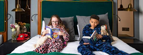 2 children reading in hotel bedroom