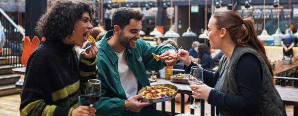 Group of friends eating food in food hall