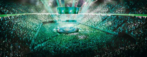 Lights shining on stage with a full crowd at AO Arena