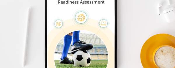 The World Cup Readiness Assessment open on a tablet on a table next to glasses and coffee.
