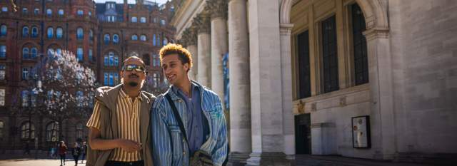2 people outside Manchester Central Library in the sun