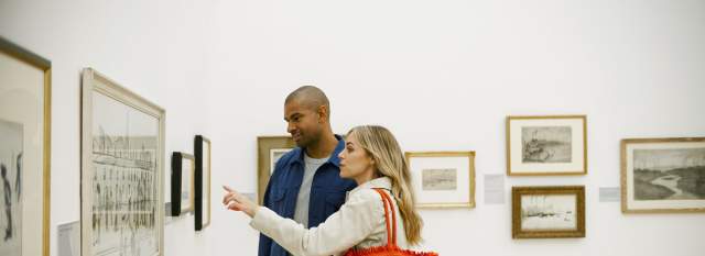 2 people in art gallery looking at photo