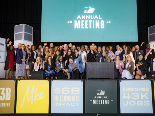 the visit milwaukee team smiling and cheering at the 2023 annual meeting