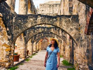Woman walking under arches at missions