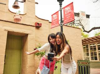 Two girls taking a selfie in outdoor shopping area