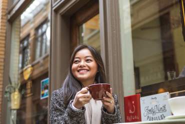 Woman sitting at table outside Comet Coffee
