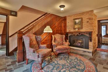 Two chairs by fireplace at Stone Chalet B & B