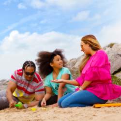 A family on the beach in Wirral building sandcastles on a clear day