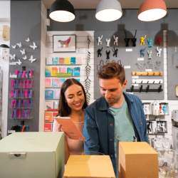 A young woman and male in their mid twenties are browsing amongst colourful homeware pieces and 'nick naks' in a quirky store.