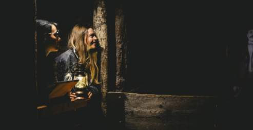 Two people with a lantern looking at a cave wall in the Nanaimo Museum.