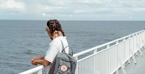 A women on a ferry looking over the railing.