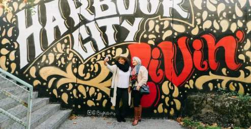 People taking a selfie at a mural.