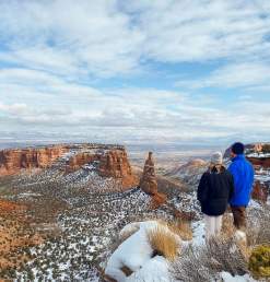 Two People Overlooking Colorado National Monument with Snow