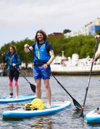 People stand up paddleboarding in Bristol harbour