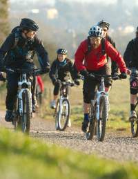 A group cycling on rented mountain bikes towards the off-road mountain biking trail at Ashton Court - credit Pedal Progression