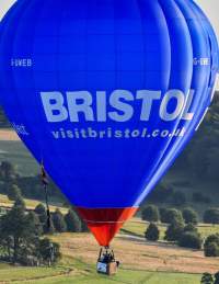 A blue balloon ascending from Ashton Court during the Bristol Balloon Fiesta with the Clifton Suspension Bridge in the background - credit Paul Gillis