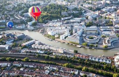 An aerial view of hot air balloons flying over Bristol Harbourside