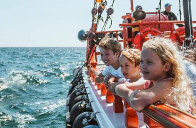 Three children looking out to sea aboard a pirate ship ride in East Yorkshire
