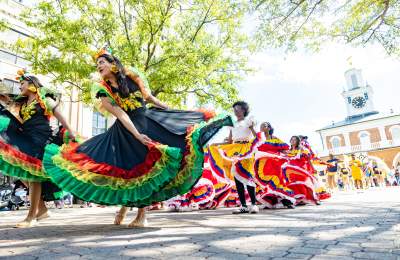 Colorful dancers performing traditional cultural dances during the Parade of Nations during the International Folk Festival in downtown Fayetteville, NC.