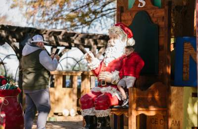 Christmas Capital of Texas kids takes picture with Santa statue
