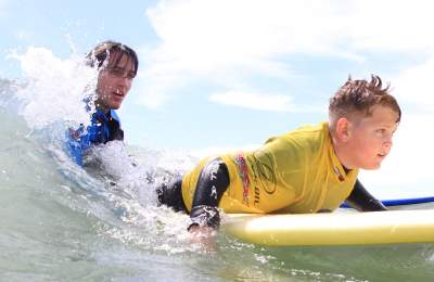 Boy learning to surf with 2XS