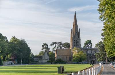St Mary's Church in the distance with blue sky and the Church Green in the foreground.