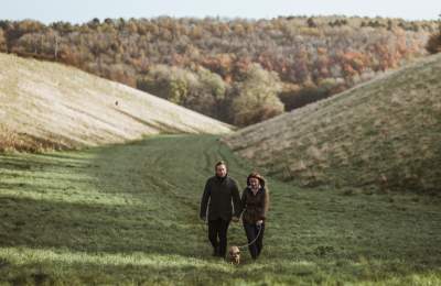 A couple walking their dog through a valley in the Yorkshire Wolds in East Yorkshire