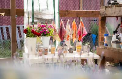 View of workbench filled with colorful flowers and jars