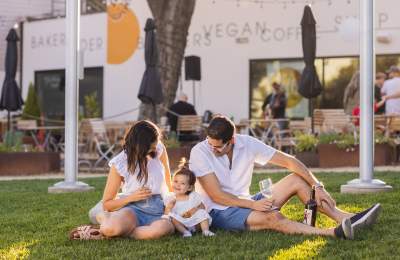 Two adults seated looking at small child all in matching outfits