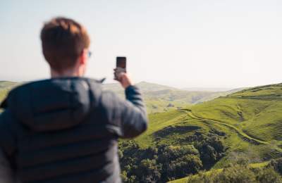 man taking picture of the rolling hills from Highway 46 west