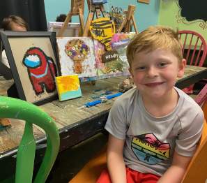 boy in a studio with painted items