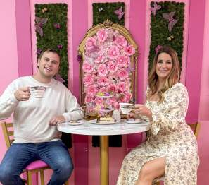 couple enjoying tea in a bright pink tearoom