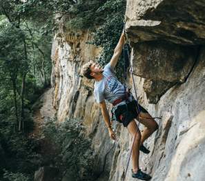 young man climbing a rock