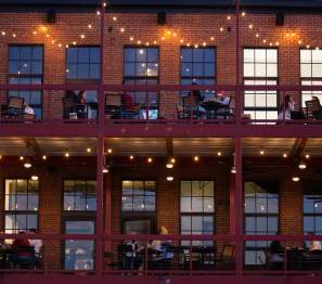 people eating outside on a two-story balcony