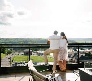 a man and woman stand on a rooftop
