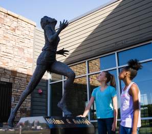 two girls admire the Wilma Rudolph statue