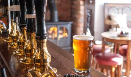 A pint of beer on a bar in a cosy pub