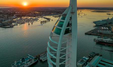 Top-down photograph of Spinnaker Tower at dusk, with the sun setting in the background