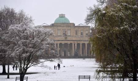 Visitors walking through a snow filled park in Cheltenham, Pittville Park in the snow