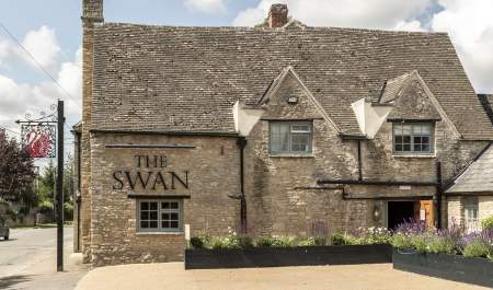 The honey-coloured stone inn with planters filled with lavender