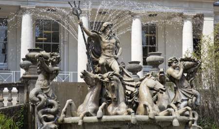 A large fountain depicting Neptune in a chariot drawn by four seahorses, accompanied by a merman blowing a conch shell