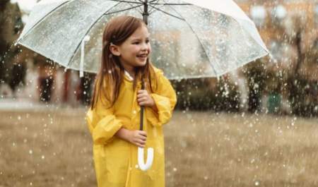 child in rain car holding an umbrella in the rain