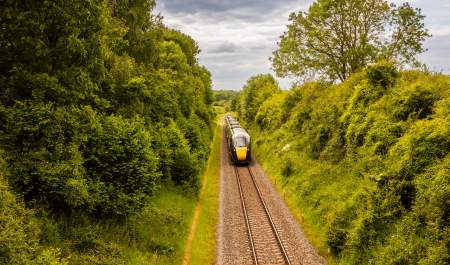A train travels past trees in the Cotswolds
