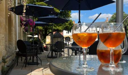 A jug and glasses of Pimms sit on a table on the sun drenched terrace of the Three Ways House Hotel