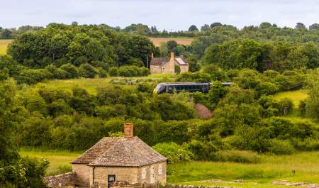 A view of North Leigh Roman Villa with a GWR train passing in the distance behind