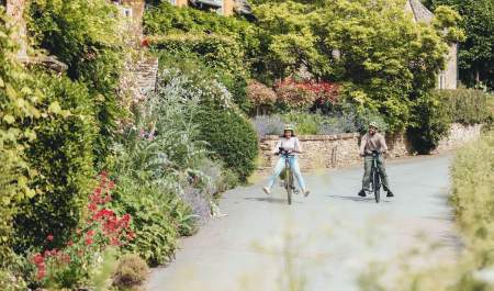 A couple free wheeling on bikes through Adlestrop