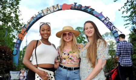 Ladies stood in front of the Cheltenham Jazz Festival sign in Montpellier Gardens, Cheltenham.