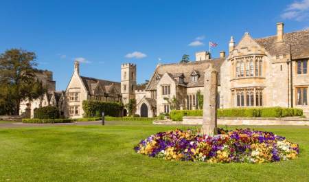 A bed of purple and yellow flowers in front of the stunning facade of Ellenborough Park