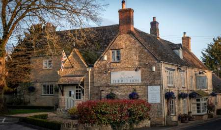Evening sun lights up the Cotswold stone brickwork of The Red Lion Long Compton in the Cotswolds